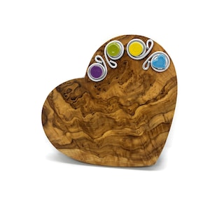 May include: A heart-shaped olive wood serving board with decorative metal swirls and colorful glass accents. The board is perfect for serving cheese, crackers, or other appetizers.