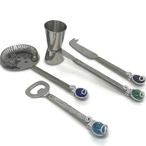 May include: A set of four silver bar tools with colorful glass accents. The tools include a cocktail shaker, a bottle opener, a strainer, and a cheese knife.