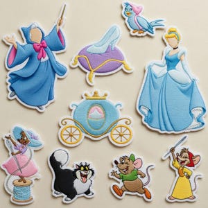 May include: A white ceramic mug with a black handle and the text "But First, Coffee" in a bold, black font. The mug is set against a blurred background, suggesting a cozy setting.