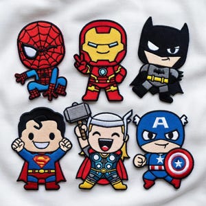 May include: Set of six colorful embroidered patches featuring popular comic book superheroes. Includes Spider-Man, Iron Man, Batman, Superman, Thor, and Captain America. Each patch has a cartoon-like design with vibrant colors and detailed stitching.