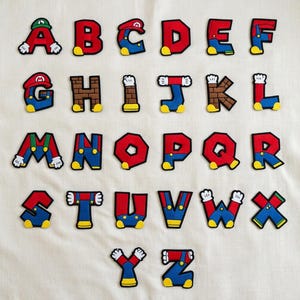 Broderad lapp med Super Mario-bokstav, Disneyland Mario Kart Yoshi-alfabetet med persikamotiv, stryk-på-jackor, mössor, väskor, personlig namnpresent