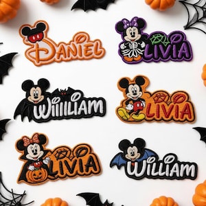 May include: Six embroidered patches featuring Disney characters and names. The patches include Mickey and Minnie Mouse in Halloween costumes, with names Daniel, Livia, and William stitched in orange, purple, red, and white thread on a white background.