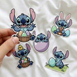 K&ouml;nnte beinhalten: Eine Sammlung von f&uuml;nf Cartoon-Aufklebern mit der Figur Stitch aus Lilo & Stitch. Die Aufkleber zeigen Stitch mit Ostereiern, einem K&uuml;ken, einem Hasen und in einem Ei. Die Aufkleber sind blau, rosa und braun.