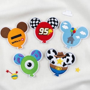 May include: A collection of embroidered patches in the shape of Mickey Mouse heads, each designed as a different character or theme. The patches feature vibrant colors and detailed stitching, including a "95" design, a cowboy, and a monster.