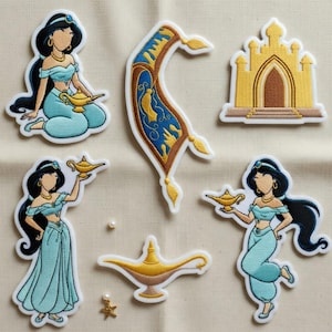 Puede incluir: Parches bordados con una princesa con un atuendo turquesa, sosteniendo una lámpara dorada. Otros parches incluyen una alfombra mágica, un palacio dorado y una lámpara dorada. Los parches tienen un borde blanco sobre un fondo beige.