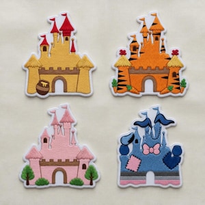 Könnte beinhalten: Vier gestickte Schlossaufnäher in Gelb, Orange, Rosa und Blau. Jeder Aufnäher zeigt ein Schlossdesign mit Türmen, Flaggen und dekorativen Elementen. Die Aufnäher sind weiß umrandet und eignen sich für die Stoffdekoration.