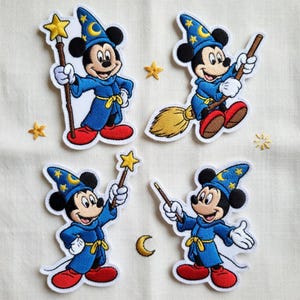 May include: Four embroidered patches featuring Mickey Mouse in a sorcerer's outfit. Mickey is wearing a blue robe and hat with gold stars and a crescent moon. Some patches show Mickey with a wand or riding a broom.