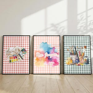 May include: Three framed rectangular wall art prints featuring a gingham pattern background. The left print shows a watercolour tote bag with art supplies. The centre print displays a colourful watercolour splash with the text Mrs. Grayson. The right print depicts a jar filled with various paintbrushes.