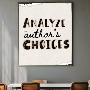 May include: A framed print with the words "ANALYZE the author's CHOICES" in black, handwritten-style lettering on a cream-colored background. The print has a torn paper effect around the edges and is set against a gray wall.