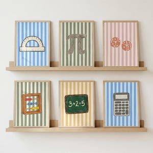 Pode incluir: Seis quadros decorativos dispostos em duas prateleiras de madeira. As impressões apresentam ilustrações de um transferidor, o símbolo pi, dois dados, um ábaco, um quadro-negro com 3+2=5 escrito em branco e uma calculadora em fundos listrados.