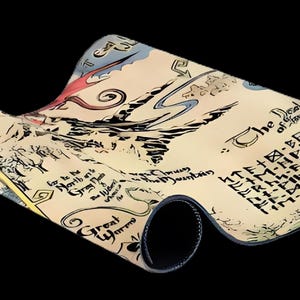 May include: A rolled-up mouse mat with a fantasy map design in cream, black, red, and blue. The map includes text and a black border. The mouse mat is set against a black background.