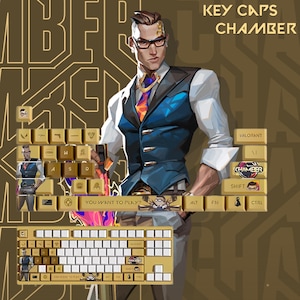 May include: Gold-colored keycaps with a Chamber theme, featuring character art and text. The keyboard keys have various symbols and text, including "YOU WANT TO PLAY?" and "CHAMBER". The background is a brown color with a repeating pattern.