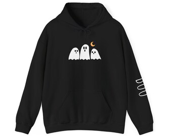 May include: Black hooded sweatshirt with a white ghost and moon graphic. The design features three white ghosts and a crescent moon. The right sleeve has the word "Boo" in white. A cozy, Halloween-themed apparel item.