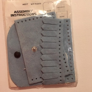 May include: A blue leather craft kit with assembly instructions. The kit includes a front and back piece, a flap with a decorative edge, and a snap button. The kit is labeled #4217 Kit Parts.