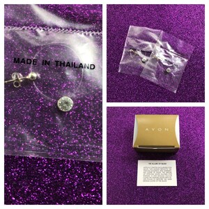 May include: A pair of silver earrings with clear crystal stones. The earrings are packaged in a clear plastic bag with a white label that reads "Made in Thailand". The earrings are also packaged in a gold box with the word "AVON" printed on it. The box also includes a small card that reads "The Allure of Silver".