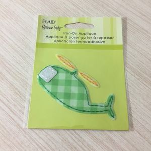 May include: Green and white checkered iron-on applique of a helicopter with yellow blades. The package says "PLAID Uptown Baby™ Iron-On Applique Applique à poser au fer à repasser Aplicación termoadhesiva"