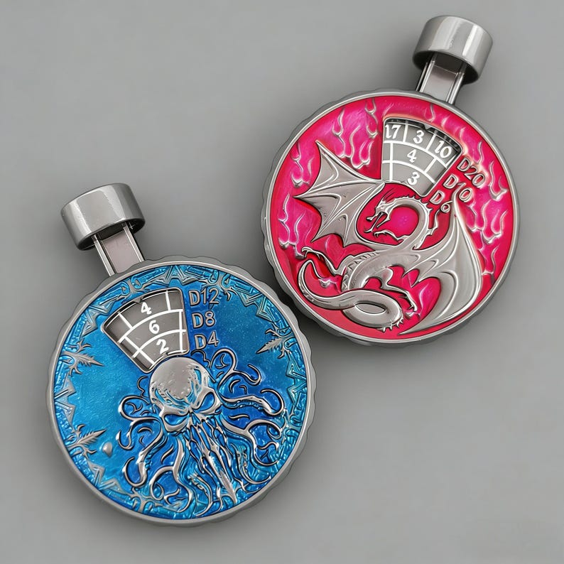 May include: Two metal dice rollers with a silver finish. One is blue with an octopus design, the other is pink with a dragon. Each has a numbered dial for D4, D8, D12, and D20 dice.