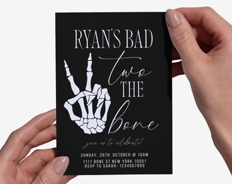 Puede incluir: Tarjeta de invitación negra con texto blanco y una mano de esqueleto. El texto dice "RYAN'S BAD Two THE Bone" e incluye detalles del evento: domingo 26 de octubre a las 10 AM, dirección e información RSVP.