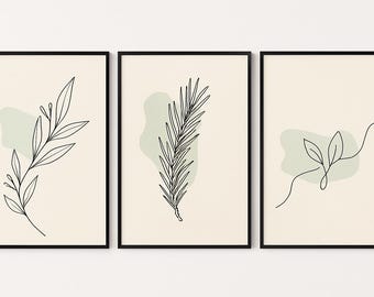 Op de afbeelding: Set van drie ingelijste kunstdrukken met minimalistische botanische lijntekeningen. Elke print toont een ander plantenelement in zwart tegen een crèmekleurige achtergrond, met een zachte groene vorm. De frames zijn zwart.