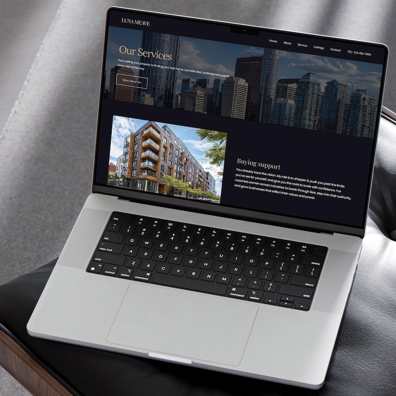 May include: A silver laptop displaying a website with the text "LUNA MEAVE" at the top. The website features images of buildings and text about services and buying support. The laptop is on a black surface.
