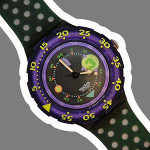 以下が含まれることがあります： 黒い文字盤、紫色のベゼル、黄色の数字が特徴のSwatchの腕時計。白いドットが付いたグリーンのストラップが付いています。文字盤には緑色の数字3と「swatch SWISS」の文字があります。