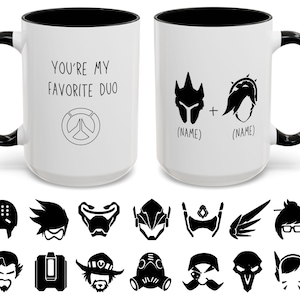 May include: Two white ceramic mugs with black handles and rims. One mug reads "YOU'RE MY FAVORITE DUO" with a logo. The other mug features two character silhouettes and the word "(NAME)". Below are black character icons.