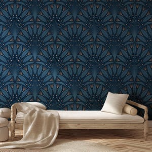 May include: Dark blue wallpaper with a repeating fan-shaped pattern in teal and gold. The design features stylized leaves and dots. A light-colored wooden daybed with white pillows and a beige blanket is in front of the wallpaper.