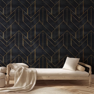 May include: A dark blue and gold geometric wallpaper with a chevron pattern. The wallpaper is paired with a light wood daybed, a beige throw blanket, and white pillows. The room has a modern, minimalist aesthetic.