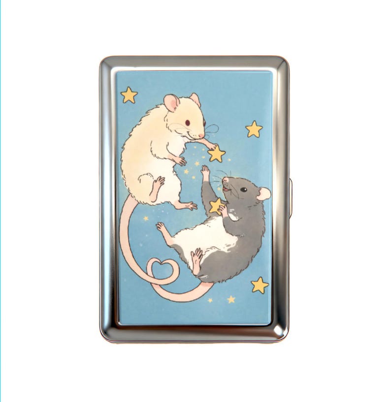 K&ouml;nnte beinhalten: Ein rechteckiges Metallgeh&auml;use mit poliertem Silberrahmen und einer hellblauen Illustration einer cremefarbenen Maus und einer grauen Maus, die zwischen gelben Sternen schweben. Die cremefarbene Maus greift nach einem Stern, w&auml;hrend die graue einen h&auml;lt.