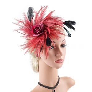 Peut inclure: Un fascinateur de plumes rouge et noir avec une rose centrale. La coiffe présente un ensemble de plumes rouges rayonnantes, rehaussées de plumes noires et d'une rose rouge foncé. Accessoire pour événements.