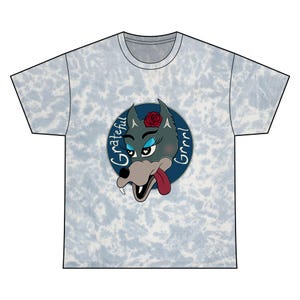 May include: Light blue tie-dye t-shirt with a cartoon wolf design. The wolf has blue eyeshadow, a red rose, and a lolling tongue. The design includes the words "Grateful Grrr!" in white script within a blue circle. Crew neck.
