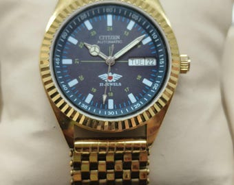 "Citizen Automatikuhr: Schwarzes Ziffernblatt, geriffelte Lünette, goldfarbenes Armband ""M.""