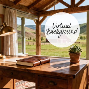 May include: A wooden desk with a brass lamp, a leather-bound book, and a potted succulent. The desk is in front of a window with a view of a green field and mountains. The text "Virtual Background" is in a white circle.