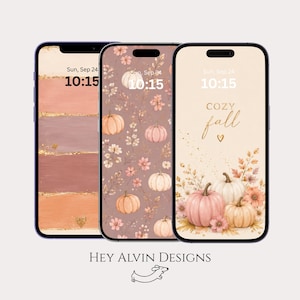 Peut inclure: Trois smartphones affichant des fonds d'écran numériques. L'écran de gauche montre des coups de pinceau horizontaux dans des tons pêche et marron avec des accents dorés. L'écran central présente un motif de petites citrouilles et de fleurs. L'écran de droite affiche des citrouilles, des fleurs et le texte "COZY fall" avec un petit cœur. Le texte "HEY ALVIN DESIGNS" apparaît en dessous.