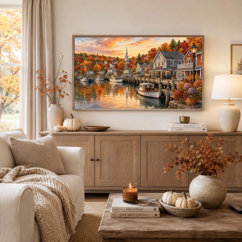 May include: A rectangular wall art print depicting a harbor scene during autumn, featuring boats docked at a wooden pier, colorful fall foliage, a church steeple, and houses under a sunset sky. The artwork is framed and displayed above a wooden console table.