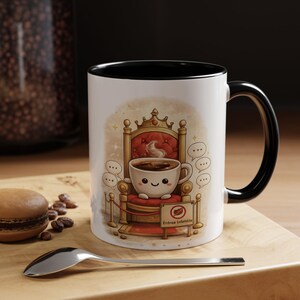 Könnte beinhalten: Weiße Keramik-Kaffeetasse mit schwarzem Innenraum und Griff. Die Tasse zeigt eine Cartoon-Illustration einer Kaffeetasse auf einem Thron. Der Thron ist rot und goldfarben, mit einem Schild "Entrée Infidèle".