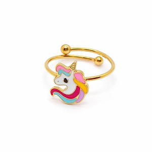 Peut inclure: Une bague ajustable dorée ornée d'un motif de licorne en émail coloré. La licorne présente un visage blanc, un œil noir et une crinière composée de sections rose, jaune, bleu clair et violet. L'anneau se termine par deux petites sphères dorées.