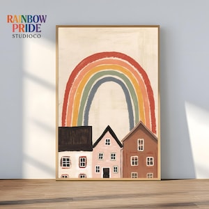 Könnte beinhalten: Gerahmter Kunstdruck mit einem Regenbogen über drei stilisierten Häusern in Braun-, Rosa- und Weißtönen. Der Druck enthält den Text "RAINBOW PRIDE STUDIOCO" in der oberen linken Ecke.