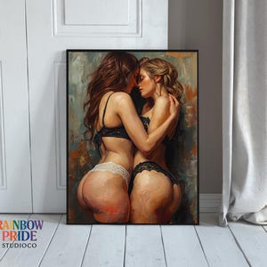 May include: Framed art print featuring an artistic depiction of two figures embracing. The figures are in lingerie, with one in black lace and the other in white lace. The artwork has a painterly style with a muted color palette. The Rainbow Pride StudioCo logo is visible.