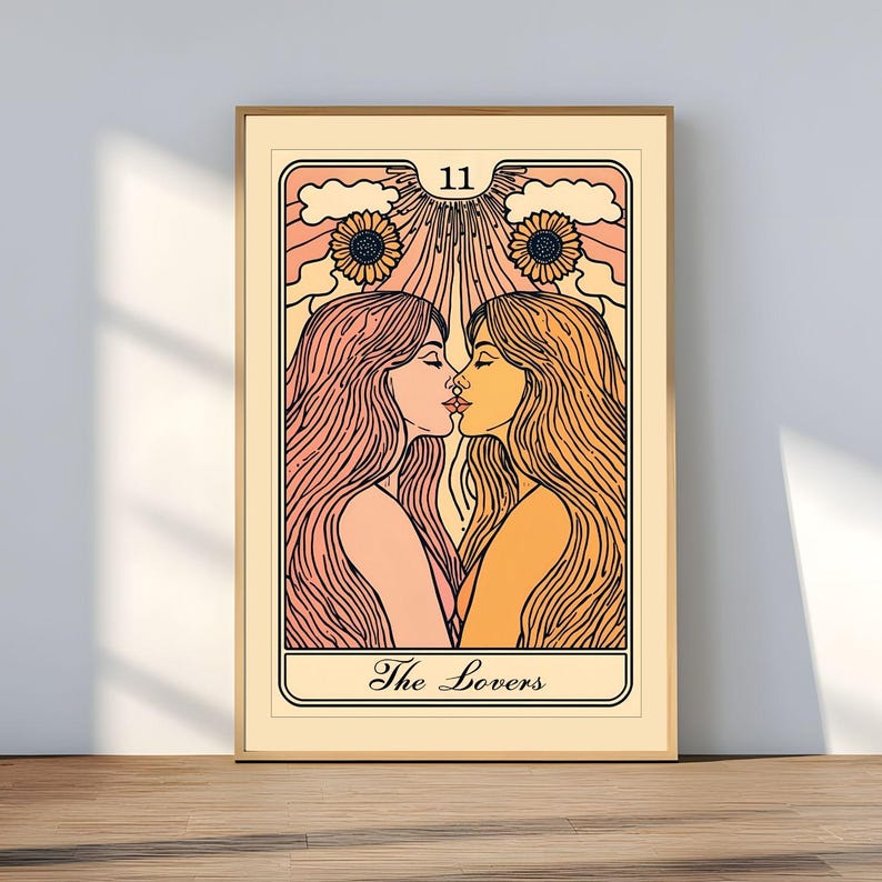 May include: Framed art print featuring a tarot card illustration. The image depicts two women kissing, with long flowing hair, set against a backdrop of sunflowers and rays. The card is labeled "The Lovers" and has the number "11" at the top.