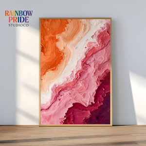 以下が含まれることがあります： 木製フレームに入った抽象的なアートプリント。このアートワークは、オレンジ、白、さまざまなピンクの色合いを使用した、テクスチャード加工されたレイヤーデザインが特徴です。「RAINBOW PRIDE STUDIOCO」の文字が左上に表示されています。