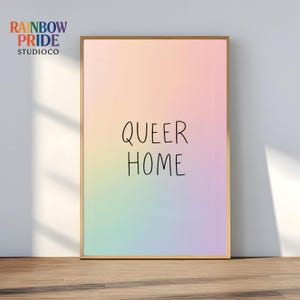 Könnte beinhalten: Ein gerahmter Kunstdruck mit pastellfarbenem Regenbogen-Verlaufshintergrund. Die Worte "QUEER HOME" sind in schwarzer Schrift geschrieben. In der oberen linken Ecke steht der Text "RAINBOW PRIDE STUDIOCO" in Regenbogenfarben.