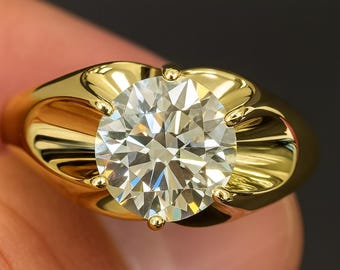 May include: A close-up of a gold ring with a large, clear, round-cut diamond. The ring's band is a polished gold, and the diamond is held in place by four gold prongs. The ring is set against a dark background.
