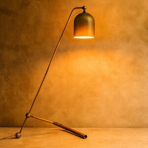 Może przedstawiać: Nowoczesna, regulowana lampa podłogowa z kloszami w kształcie dzwonu. Lampa posiada smukłe, kątowe ramię i ciemnobrązową drewnianą podstawę. Klosz ma gradient zieleni i złota, rzucając ciepłą poświatę. Wysokość lampy to około 152 cm.