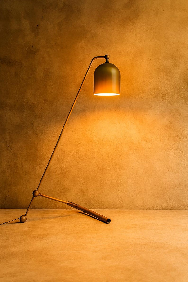 Może przedstawiać: Nowoczesna, regulowana lampa podłogowa z kloszami w kształcie dzwonu. Lampa posiada smukłe, kątowe ramię i ciemnobrązową drewnianą podstawę. Klosz ma gradient zieleni i złota, rzucając ciepłą poświatę. Wysokość lampy to około 152 cm.