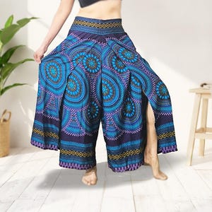 May include: Wide-leg, split-front pants with a vibrant blue and purple mandala pattern. The pants feature a high waist with a decorative band and are made of a lightweight fabric. The design includes intricate circular and paisley-like motifs.