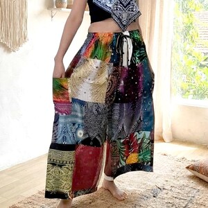 May include: Wide-leg pants featuring a vibrant patchwork design with various colorful patterns including paisley, floral, and geometric prints. The pants have an elastic waistband with a drawstring tie and two side pockets, crafted from lightweight fabric.