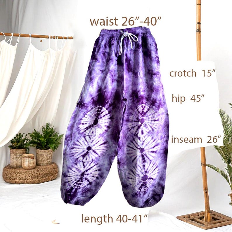 May include: Purple tie-dye pants with a drawstring waist. The pants have a waist size of 26"-40", a crotch of 15", a hip measurement of 45", an inseam of 26", and a length of 40"-41". The fabric features a white circular pattern.