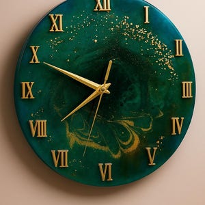 Puede incluir: Reloj de pared redondo con diseño verde azulado y dorado. La esfera del reloj presenta números romanos y manecillas doradas. El fondo verde azulado tiene un efecto veteado con motas y remolinos dorados.