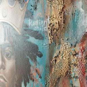 May include: Close-up of a mixed-media painting featuring a portrait of a person wearing a crown. The artwork incorporates teal, gold, and brown tones with the text "Radiant Child". The painting has a textured, layered appearance.